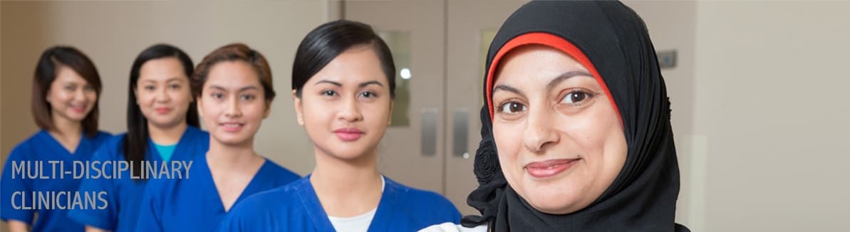 four women in blue scrub suit and another woman in a white lab coat and hijab