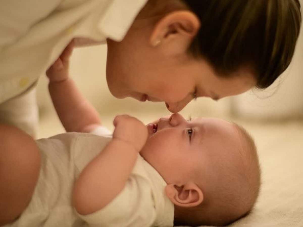 A mother and child looking at each other while their noses touching