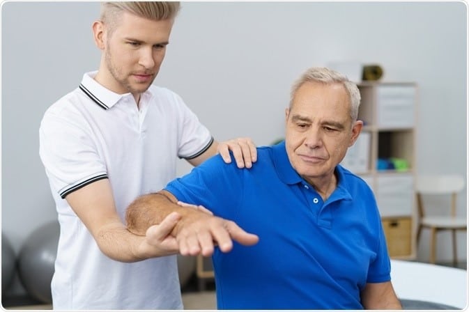 Physiotherapist and his elderly patient during a physiotherapy session