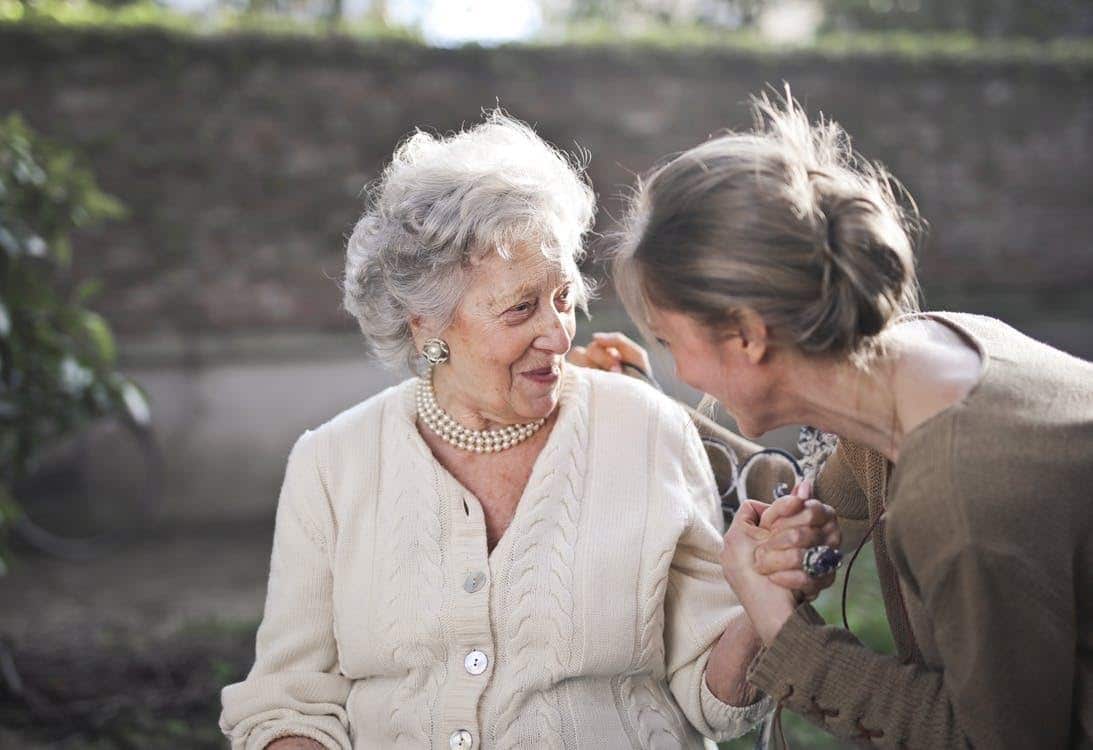 elderly woman smiling while talking to her family member or caregiver